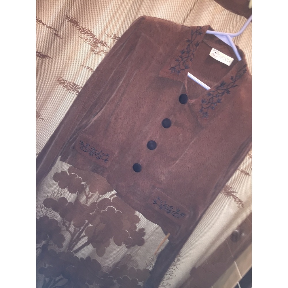 A brown blouse with black designs.